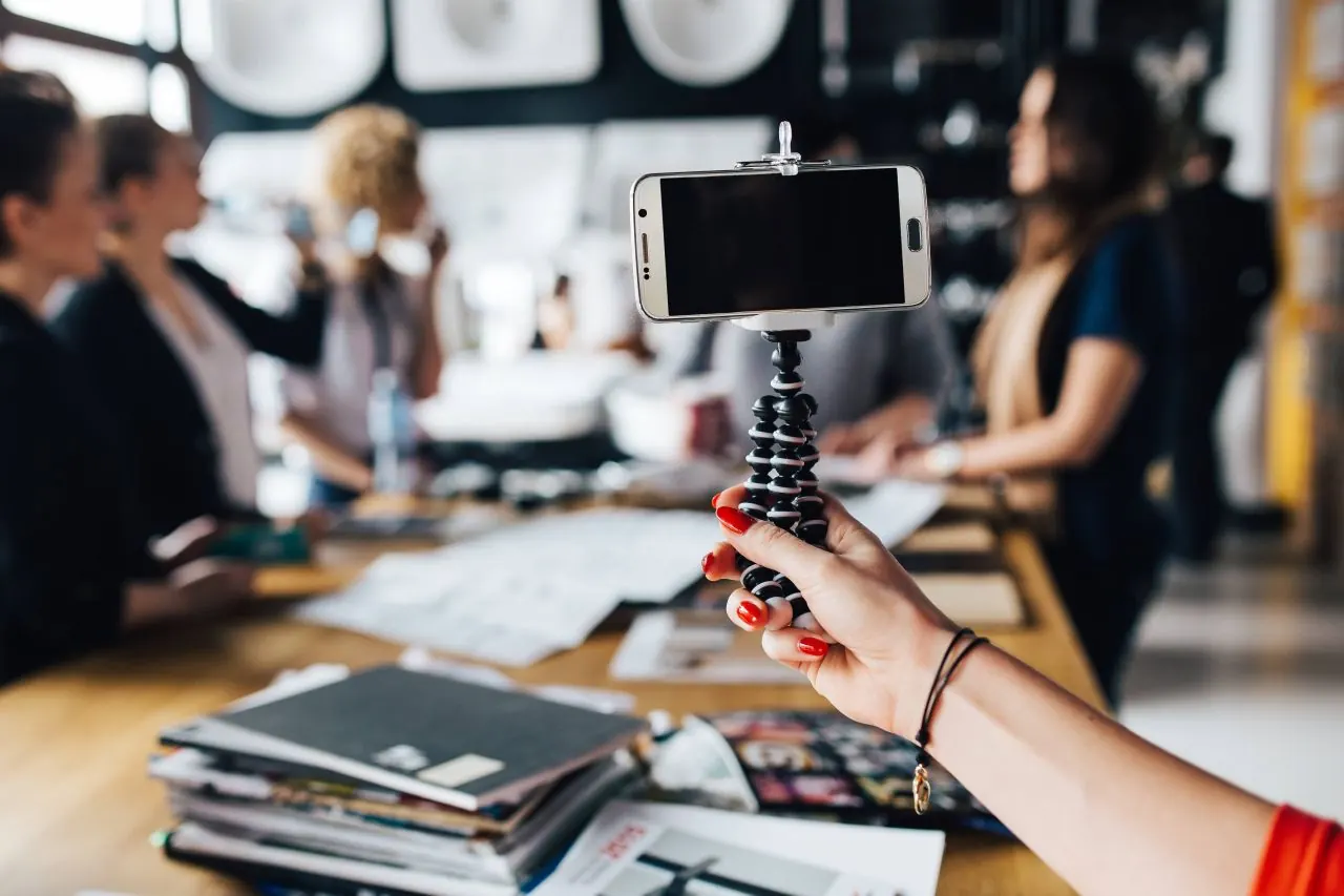 Team planning social media content with a phone on a tripod